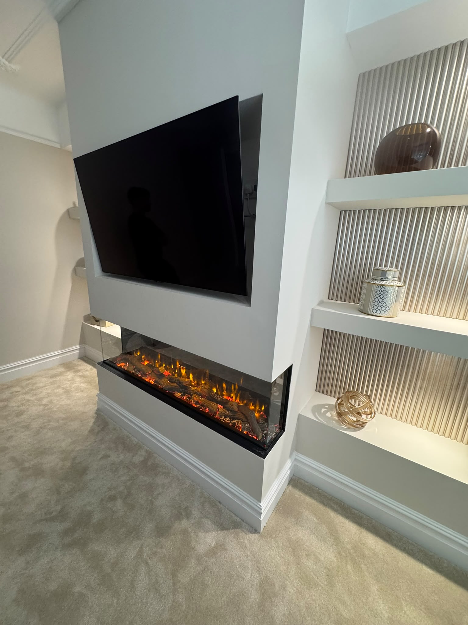 Media wall with wall-mounted TV, electric fire and LED shelf lighting